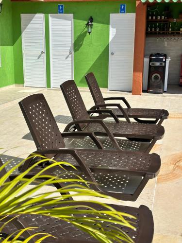 a group of chairs sitting in front of a building at KETHALYA TAYRONA Hostal in El Zaino