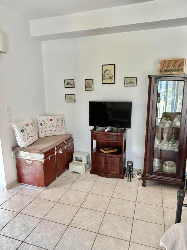 a living room with a flat screen tv and a couch at Althaea in Monemvasia