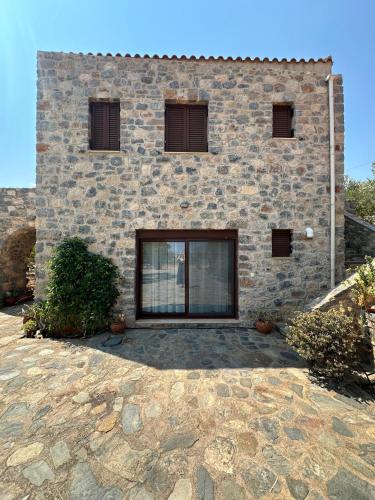a brick building with windows and a stone patio at Althaea in Monemvasia