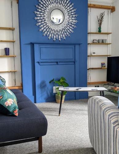 a blue living room with a couch and a table at Central Worthing apartment in Worthing