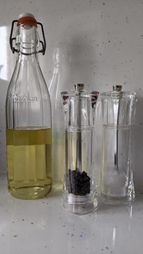two bottles of oil and a glass container with black liquids at Central Worthing apartment in Worthing