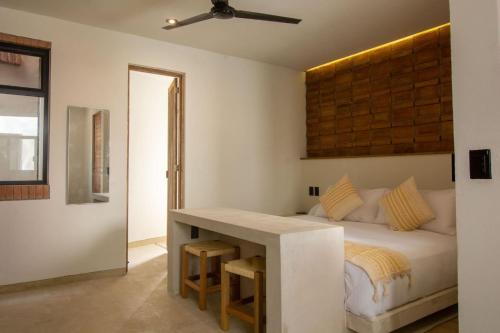 a bedroom with a bed and a table with stools at Aymara Punta Zicatela in Brisas de Zicatela