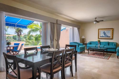 a dining room with a table and chairs and a couch at Rent Portobello Marina y Villas in Puerto Aventuras