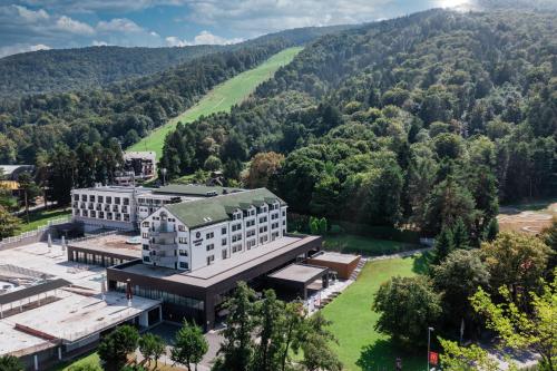 an aerial view of a building with mountains in the background at HABAKUK Wellness & Event Hotel in Maribor