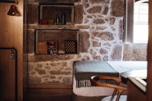 a room with a table and a stone wall at Story Studio Sortelha - Heritage in Sortelha