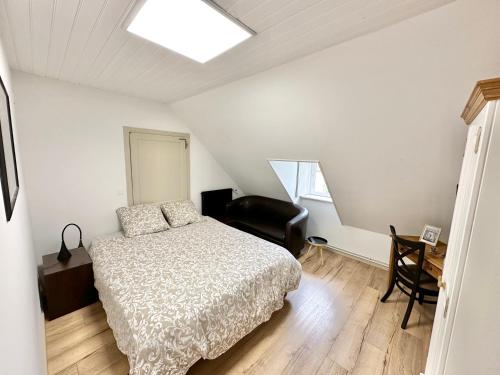 une chambre avec un lit, un bureau et une chaise dans l'établissement Appartement vintage - Terrasse - Fauteuils de cinéma, à Verton