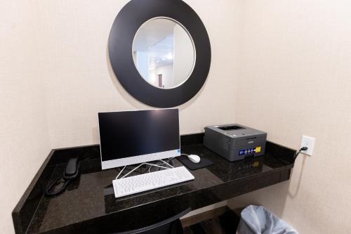 a desk with a computer and a printer and a mirror at Cobblestone Inn & Suites - Winters in Winters