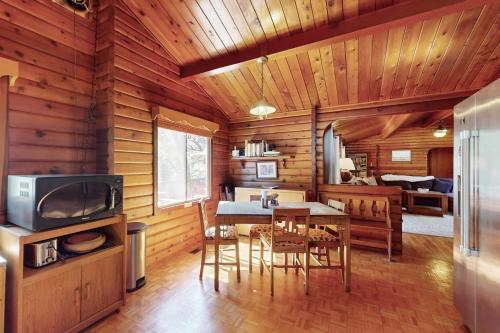 a dining room with a table in a log cabin at Log Cabin on the River in Hawkins Bar