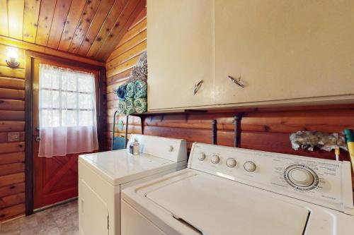 a kitchen with a washer and dryer in a cabin at Log Cabin on the River in Hawkins Bar