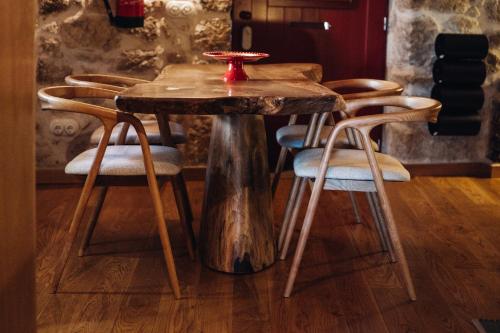 a wooden table with chairs and a table with a tree stump table at Story Studio Sortelha - Heritage in Sortelha