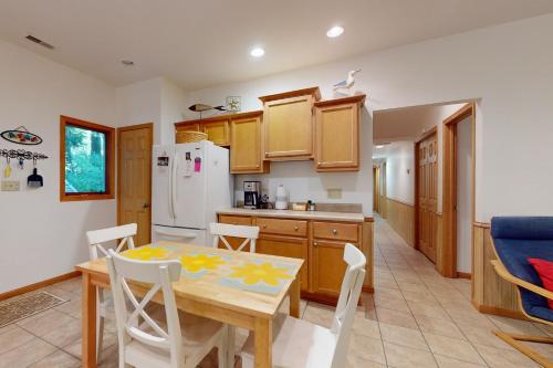 a kitchen and dining room with a table and chairs at In The Woods, by The Water in Harbert