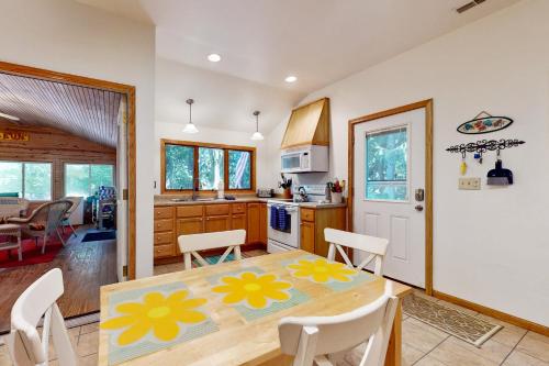 a kitchen and dining room with a table and chairs at In The Woods, by The Water in Harbert