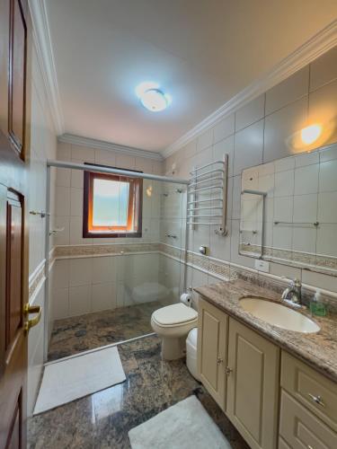 a bathroom with a toilet and a sink at Araucária Lodge - 800 metros do Capivari in Campos do Jordão