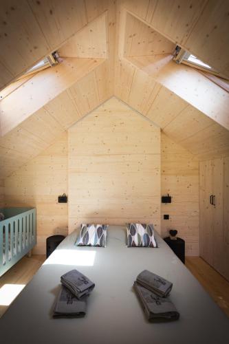 une chambre avec un grand lit dans un grenier dans l'établissement La Cabane des Prés, à Ban-sur-Meurthe-Clefcy