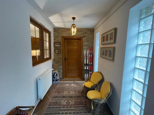 a hallway with two chairs and a door at Snow White Chalet in Brezovicë