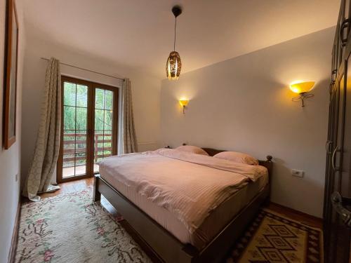 a bedroom with a bed and a large window at Snow White Chalet in Brezovicë
