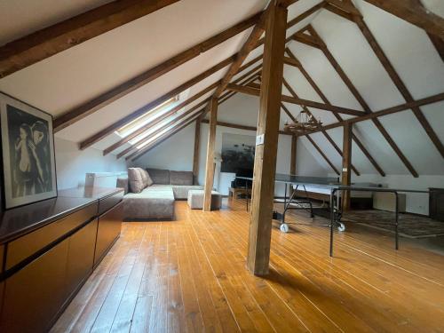 an attic room with a table and a couch at Snow White Chalet in Brezovicë