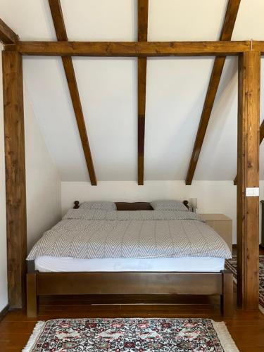a bed in a room with wooden beams at Snow White Chalet in Brezovicë