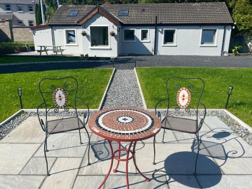 a table and two chairs and a table and a house at Joy's River Lodge in Killorglin