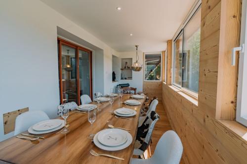 une salle à manger avec une longue table en bois et des chaises dans l'établissement Au pied du télécabine & gare St Gervais, à Saint-Gervais-les-Bains