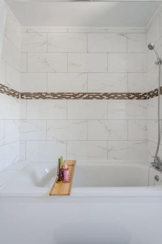 a white bathroom with a tub and a sink at Urban Oasis 4 bedroom house with parking in Chatham
