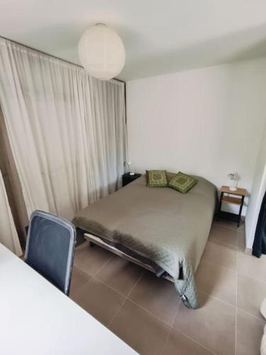 une chambre avec un lit et une chaise dedans dans l'établissement Maison en résidence, à Ollioules