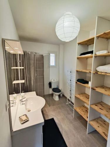une salle de bain avec un lavabo, des toilettes et un miroir dans l'établissement Maison en résidence, à Ollioules