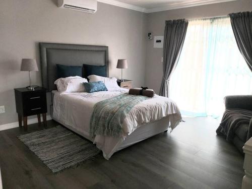 a bedroom with a bed and a large window at Hidden Gem in Bloemfontein