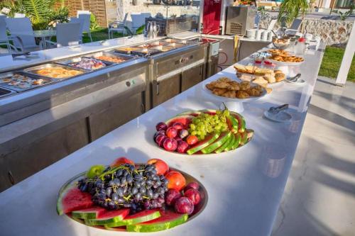 a table with plates of fruits and vegetables on it at Alia Suites and Spa in Haraki