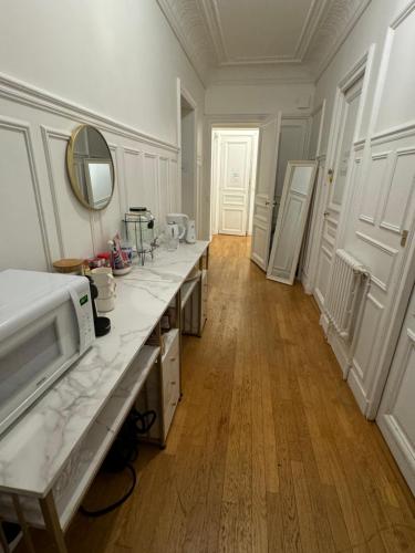 a kitchen with white counters and a mirror on the wall at Beautiful Rooms nearby Champs Elysées in Paris