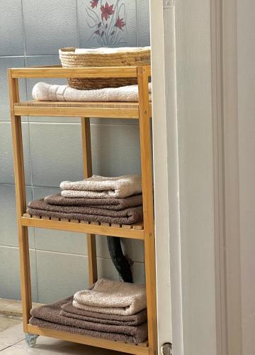 a wooden towel rack with towels in a bathroom at Central Comfort Guesthouse in Larisa