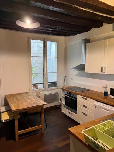 une cuisine avec une table et une cuisinière four supérieur dans l'établissement Appartement Saint-Germain-Des-Prés, à Paris