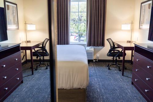 a hotel room with a bed and desks and a window at Cobblestone Inn & Suites - Winters in Winters