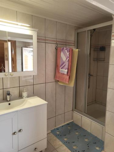 a bathroom with a sink and a shower with a mirror at House Violeta in Nida