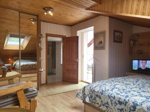 a bedroom with a bed and a sliding glass door at House Violeta in Nida