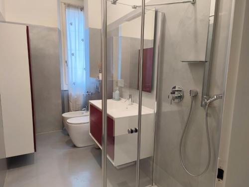 een badkamer met douche, wastafel en toilet bij CityLife & Fiera Milano Apartment with AC, WiFi, Metro M1 and Airport link in Milaan