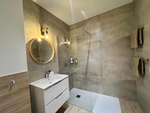 Un baño con ducha, lavabo y espejo. en Ocean Touch, en Morro del Jable