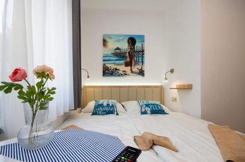 a bedroom with a bed with a vase with a remote control at Családi kikötő apartman in Gyula