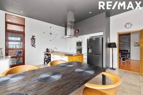 a kitchen with a wooden table and a refrigerator at Amazing Villa With Hot Tub Near Reykjavík in Lágafell