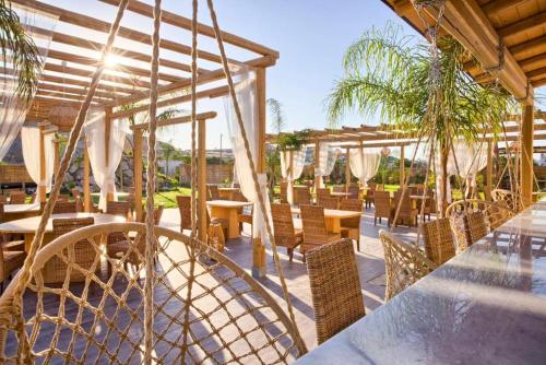 a patio with tables and chairs and trees at Alia Suites and Spa in Haraki