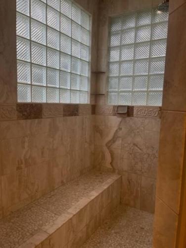 a shower with two windows and a bench in a bathroom at Old Kinderhook Castle in Roach