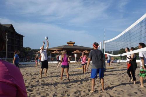 a group of people playing volleyball on a beach at Old Kinderhook Castle in Roach