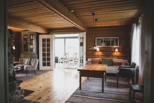 a living room with a couch and a table at Forest Ranger's House, Authentic Lappish atmosphere in Äkäslompolo