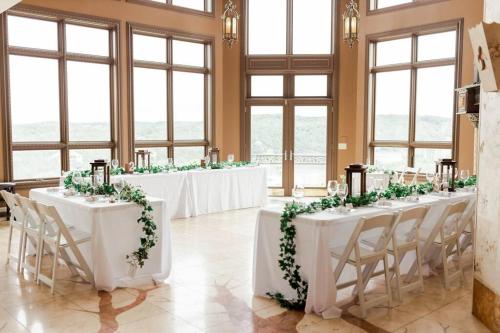 a row of tables in a room with flowers on them at Old Kinderhook Castle in Roach