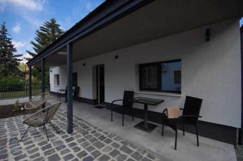 a patio with chairs and a table on a building at Családi kikötő apartman in Gyula