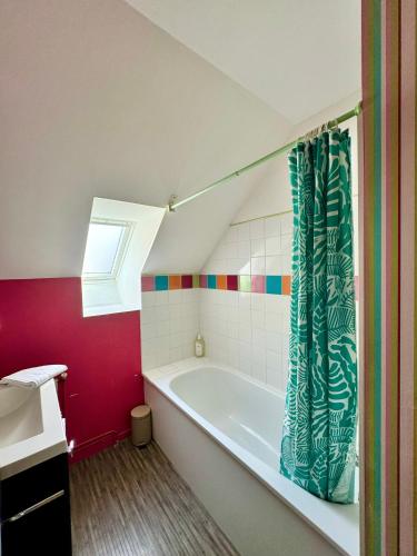La salle de bains est pourvue d'une baignoire avec rideau de douche. dans l'établissement Le petit Rennes Est, à Rennes