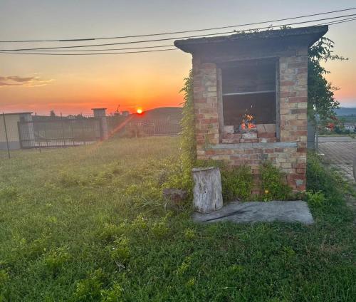 a brick fireplace in a field with the sunset in the background at CASA FRIDA Intero alloggio con due camere in Canelli