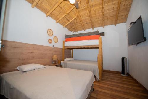 a bedroom with two beds and a flat screen tv at Hermosa Casa con Piscina y Playa Privada in San Martín