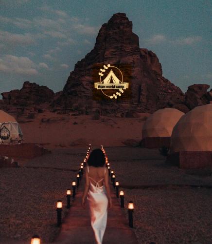 a woman walking down a path with candles in the desert at RUM WORLD BUBBLE lUXURY CAMP in Wadi Rum