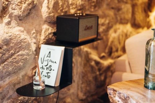 a sign on a shelf with a candle and a box at Story Studio Sortelha - Heritage in Sortelha